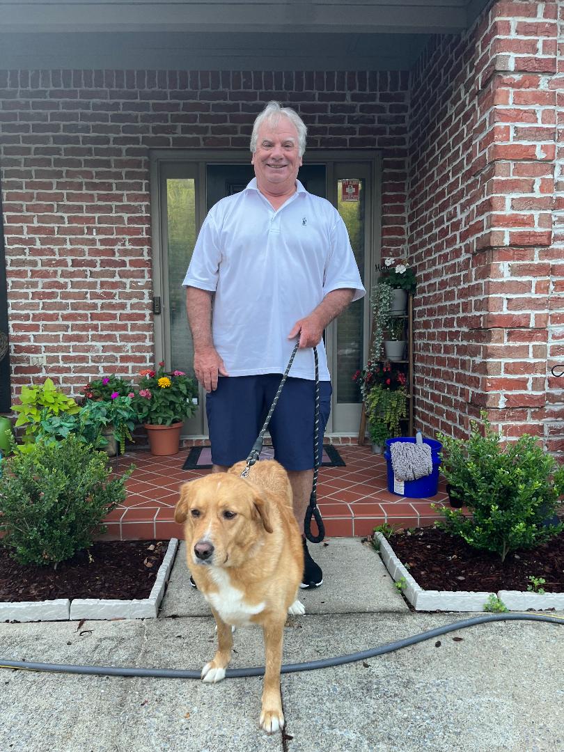 Man standing with a golden retriever mix on a leash