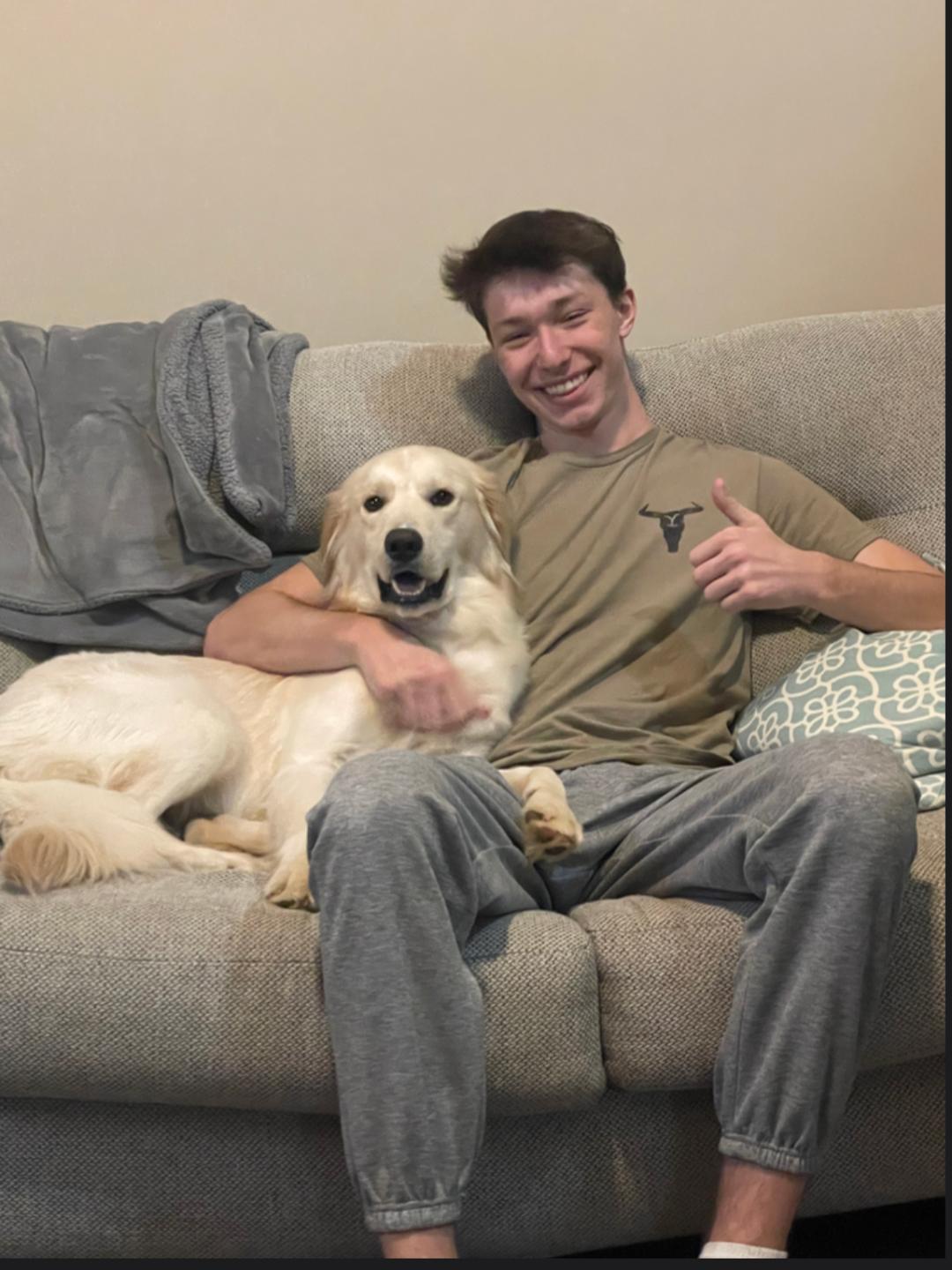 Man sitting on couch with golden retriever