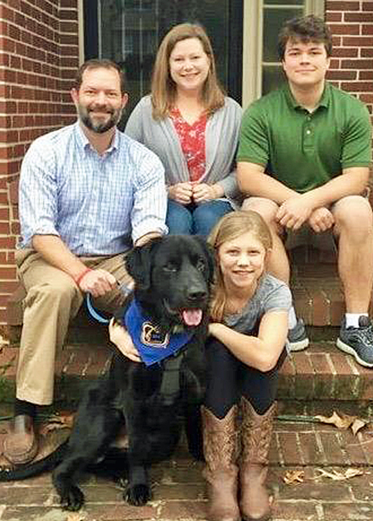Family of mom, dad, older brother, little sister, and a black golden retriever